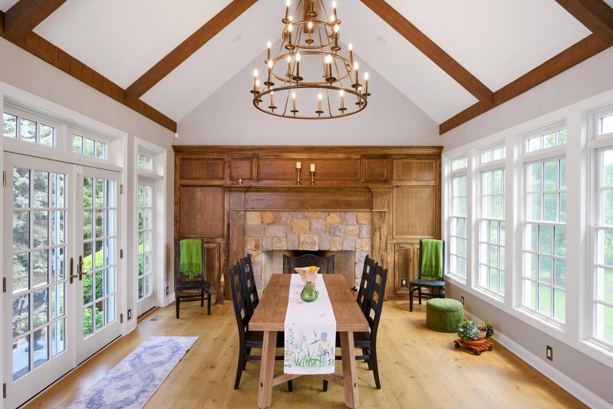 4-season room addition dining table in front of fireplace by GTG Builders in Central, NJ